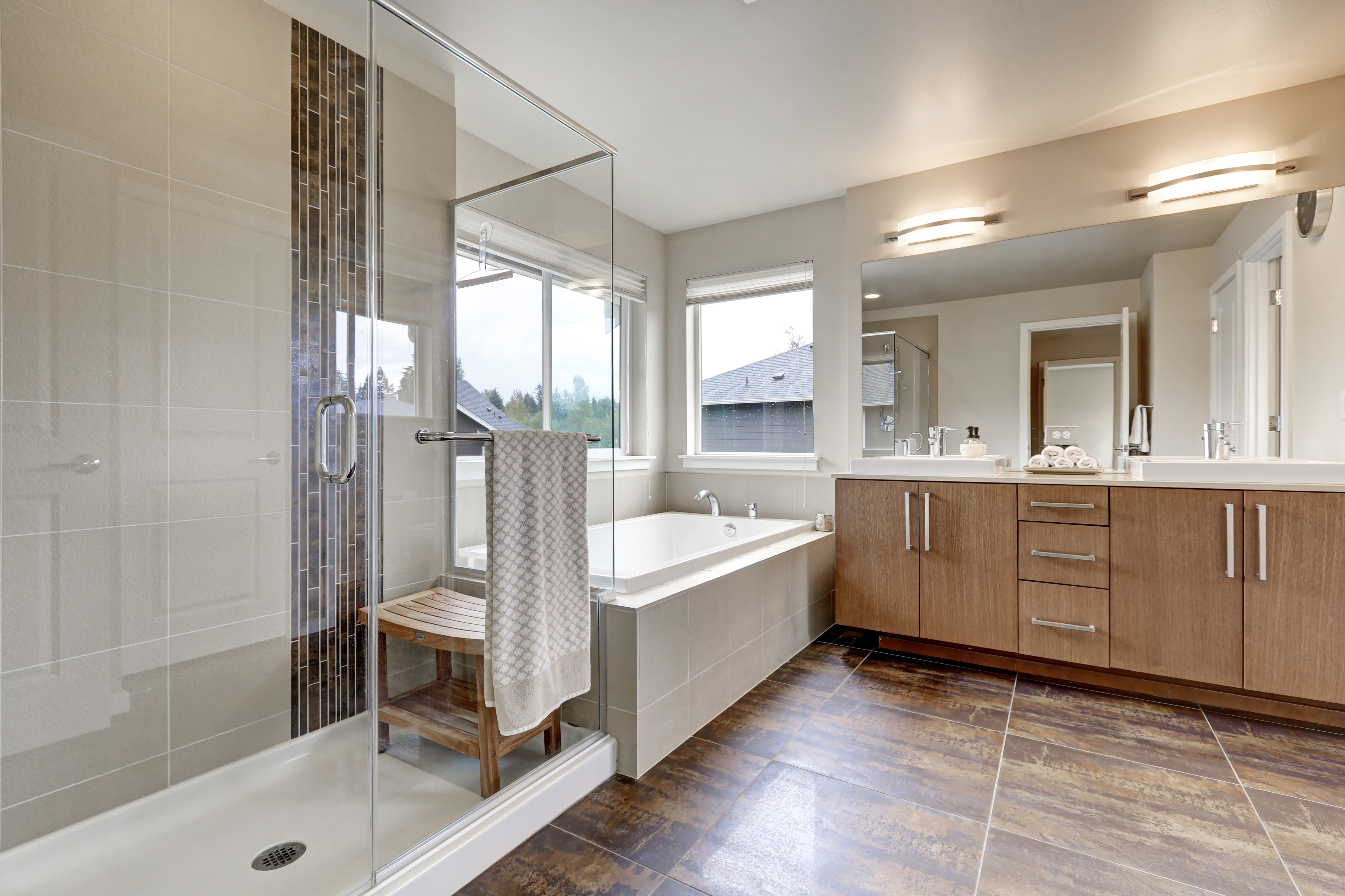 Large floor to ceiling bathroom vanity and a white bathtub