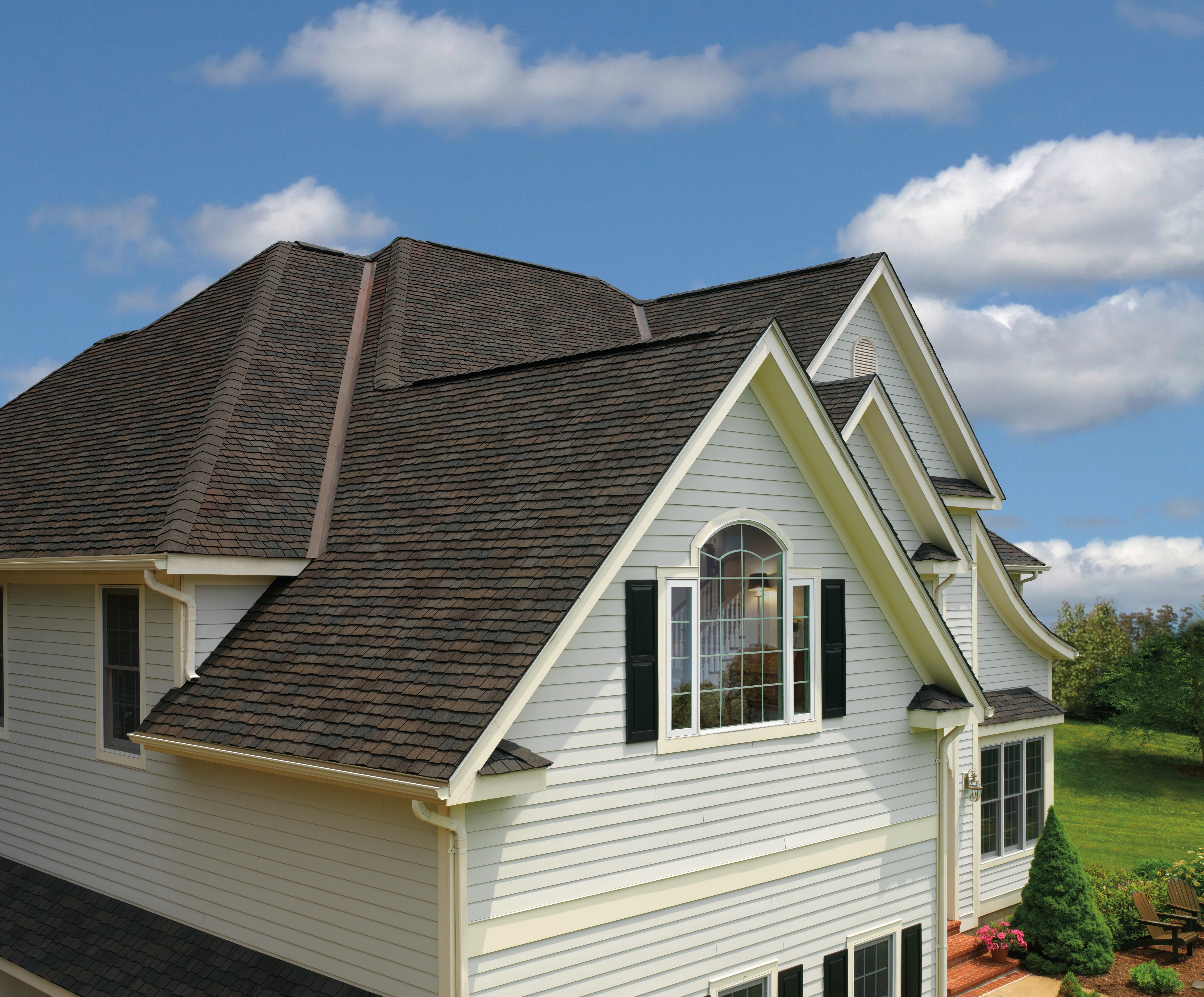 A dark brown roof on light beige siding for a striking exterior remodel