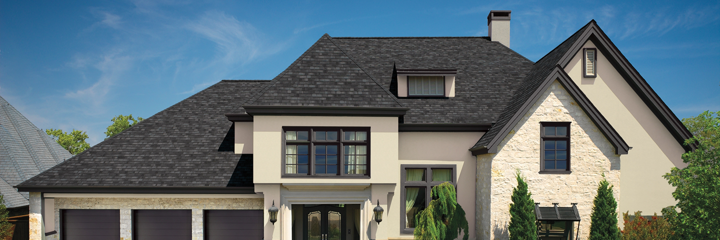 A brown roof on a modern home set on a blue sky