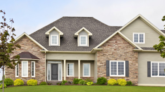 House with brick siding, white windows, and dark shingles